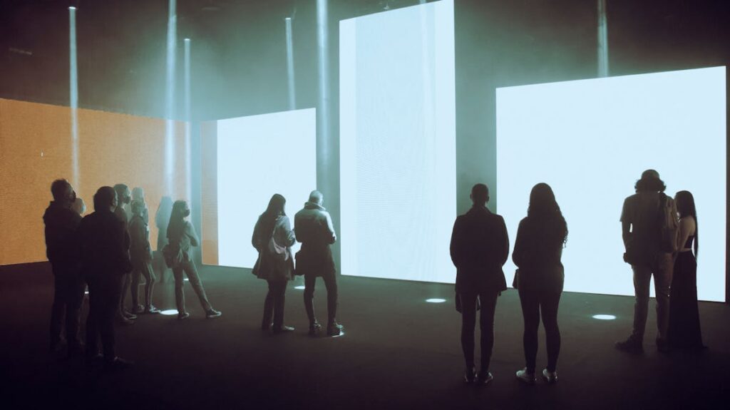 Visitatori in un museo davanti a schermi digitali - NFT e tokenizzazione